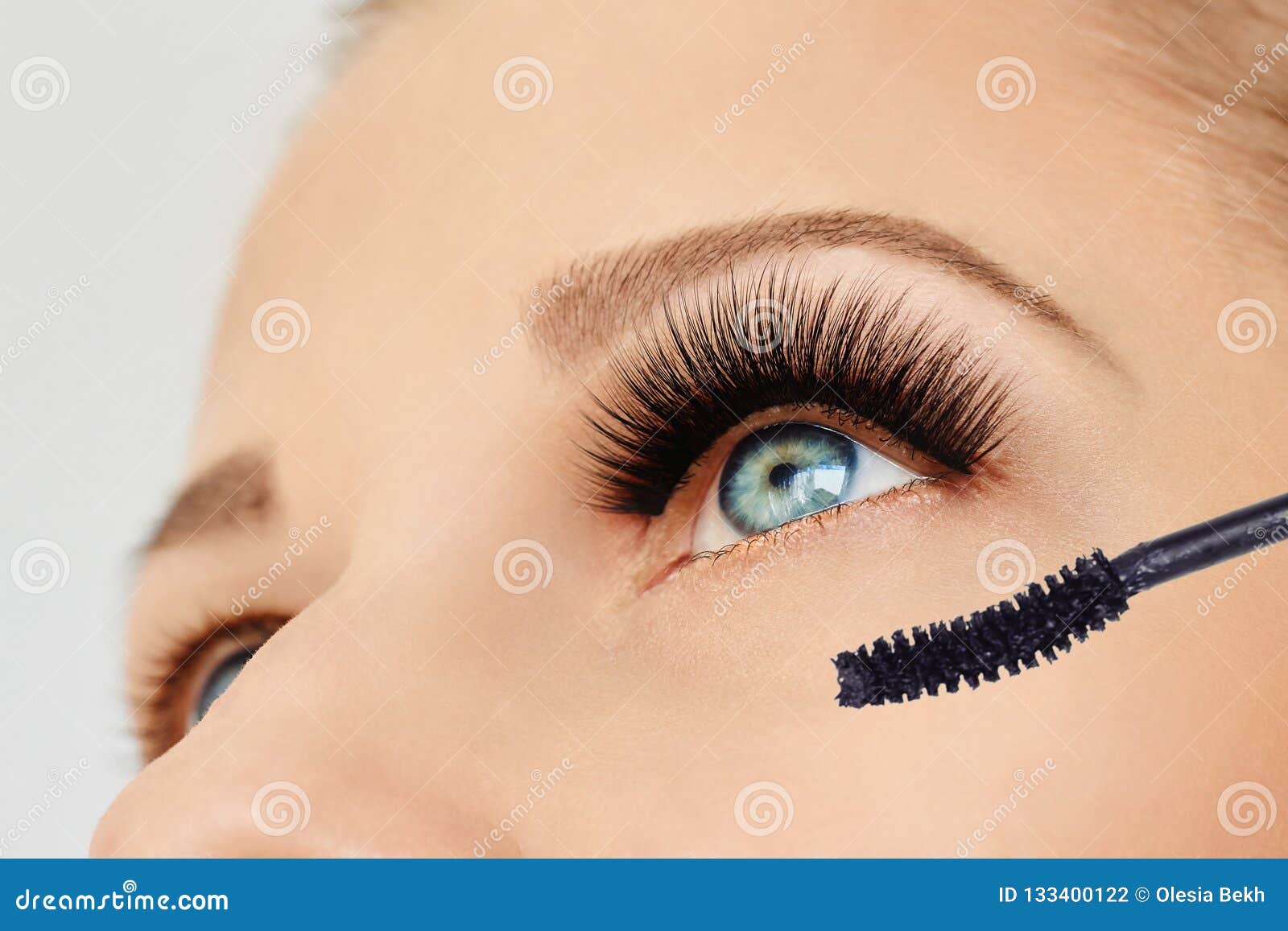 female eye with extreme long eyelashes and brush of mascara. make-up, cosmetics, beauty