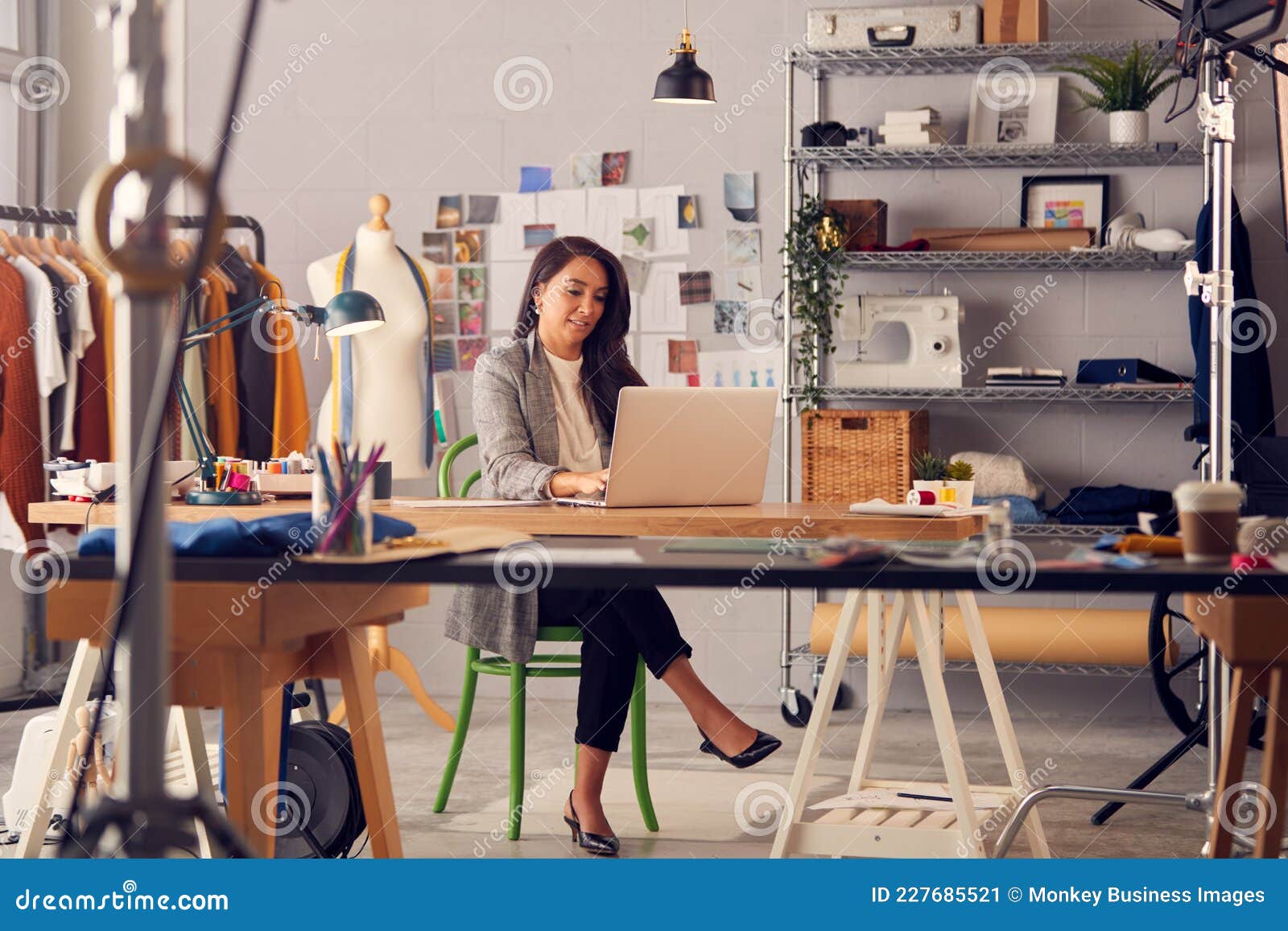 Female Fashion Designer in Studio Working on Sketches or Documents at ...