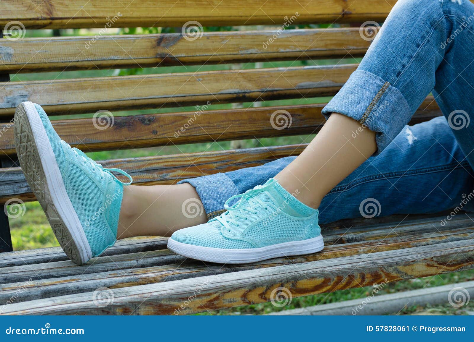 Female Feet in Jeans and Sports Shoes on a Bench Close-up Stock Image ...