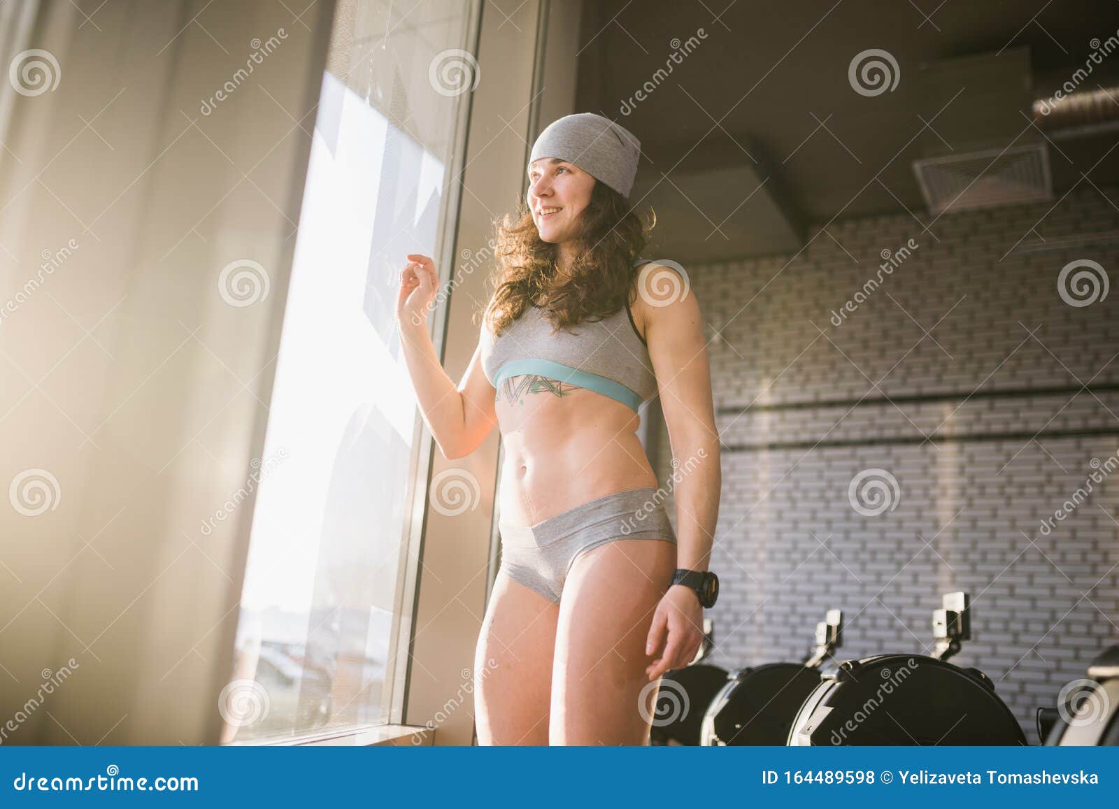 Female Fitness Model In Top Posing Near Big Window Fitness Model Have