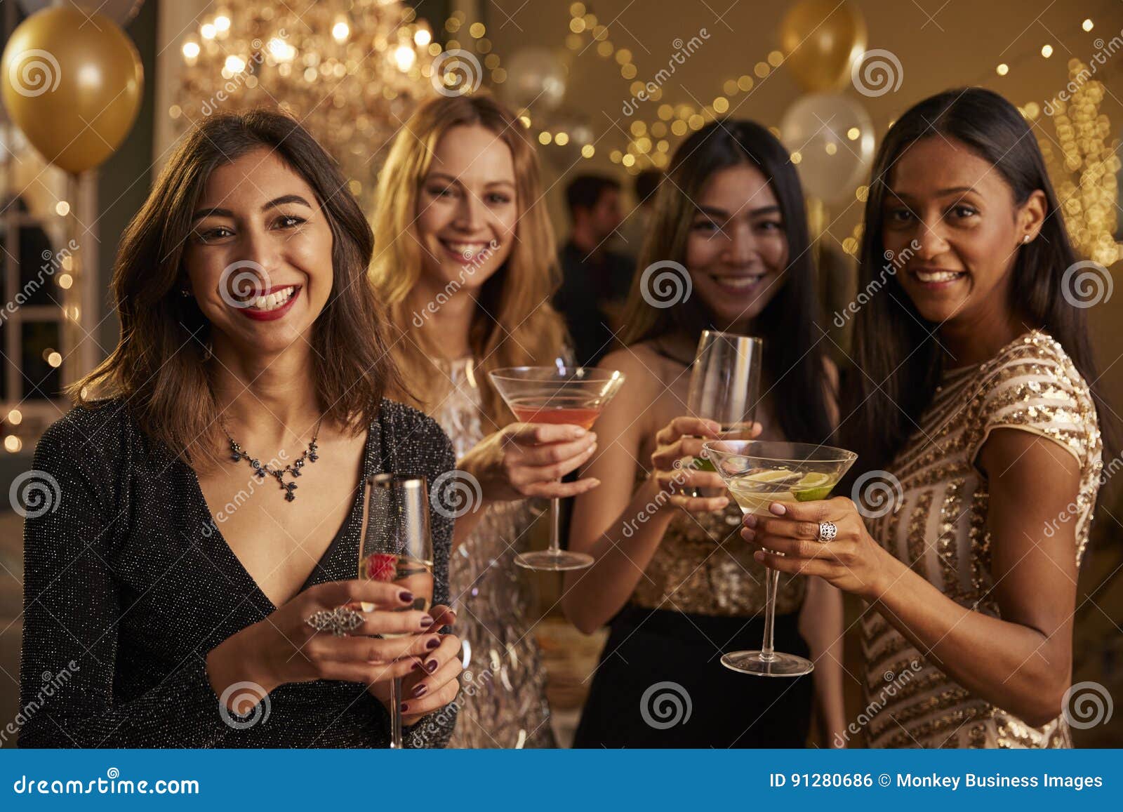 female friends celebrating at party make toast to camera