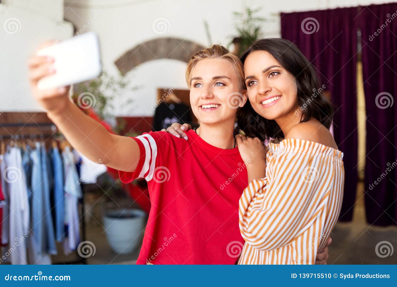 Female Friends Taking Selfie at Clothing Store Stock Photo - Image of ...