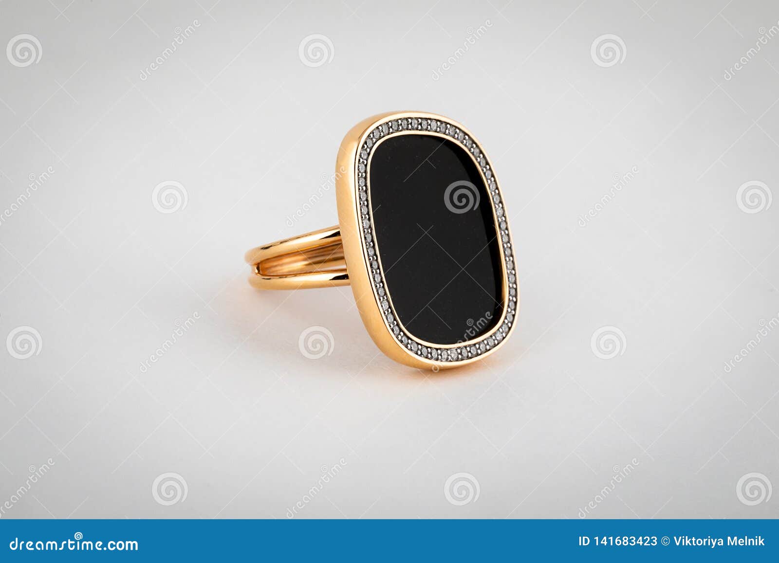 Female, Gold Ring with a Large Black Stone in the Middle, on a White