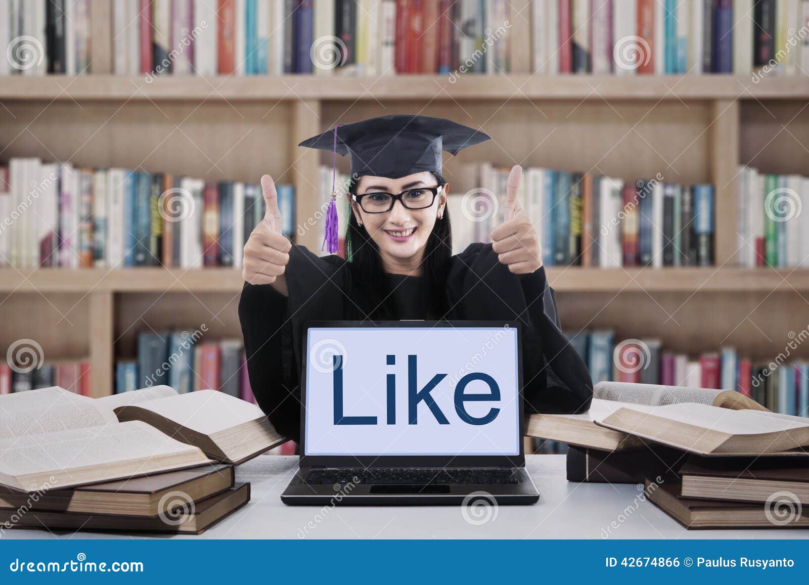 Female Graduate Thumbs Up in Library Stock Photo photo image