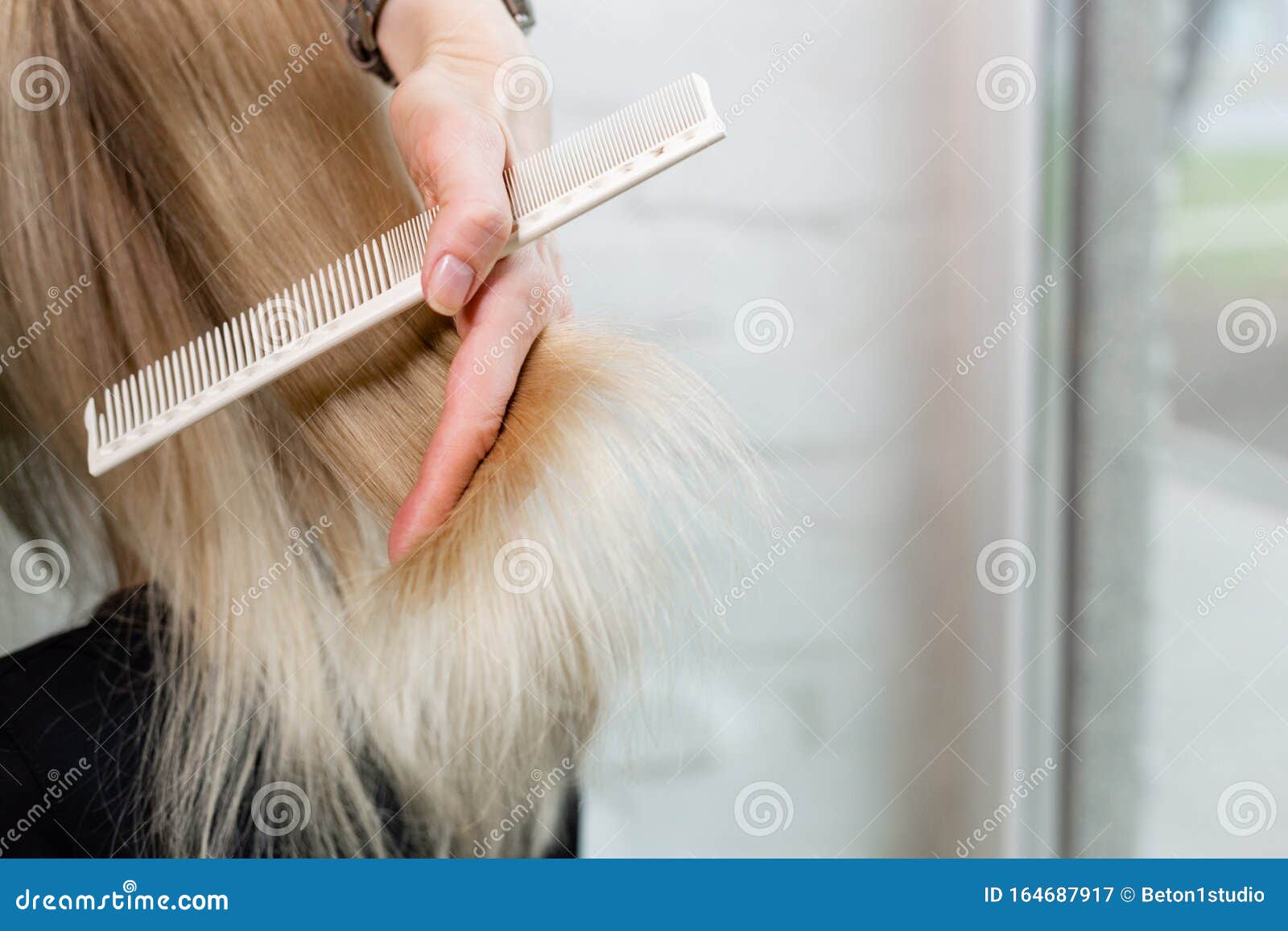 Female Hairdresser Doing Haircut On Blonde Hair Keratin