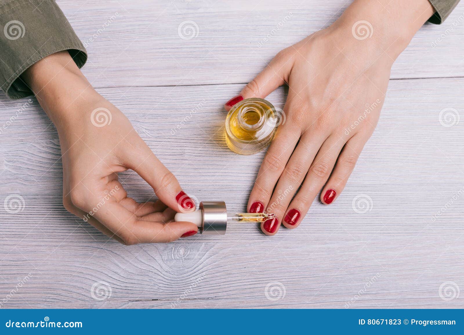 female hand applied oil on the nails