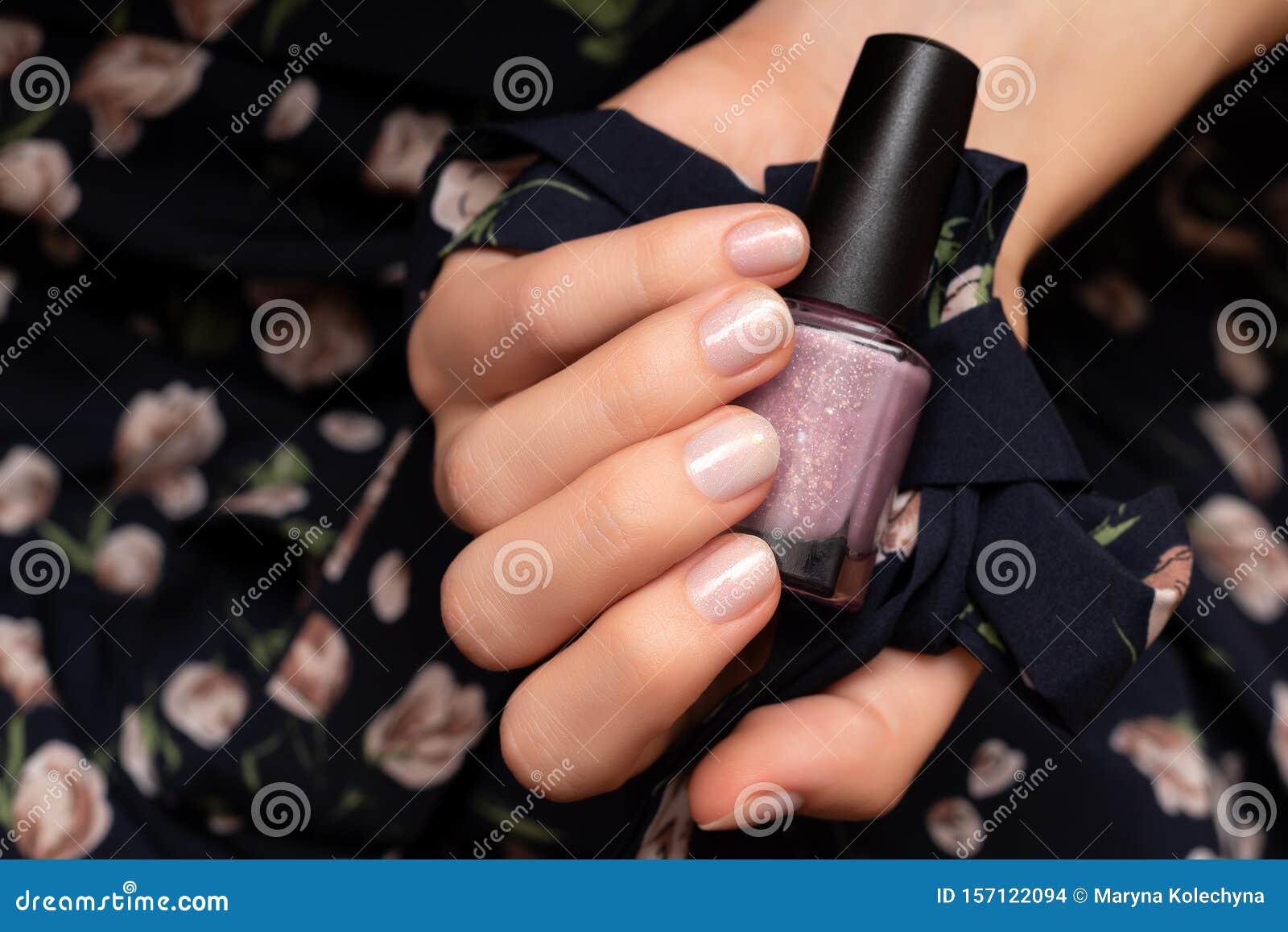 Female Hand With Glitter Nail Design Holding Nail Polish Bottl