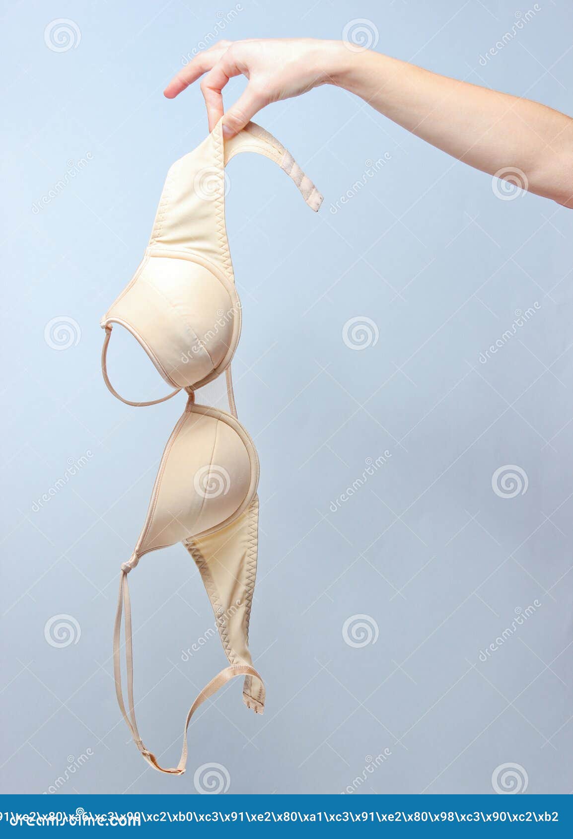female hand holding beige bra