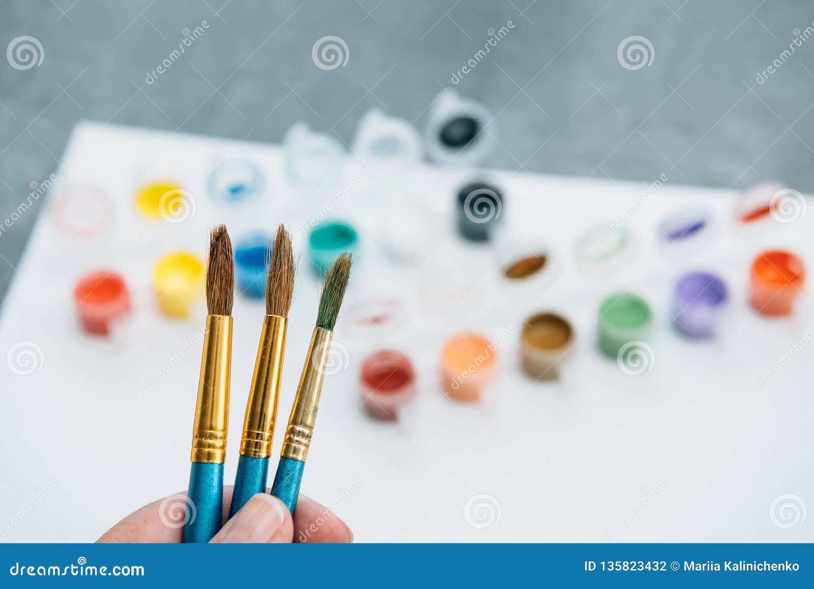 Female Hand Holding Paintbrushes on Palette of Opened Acrylic Paints ...