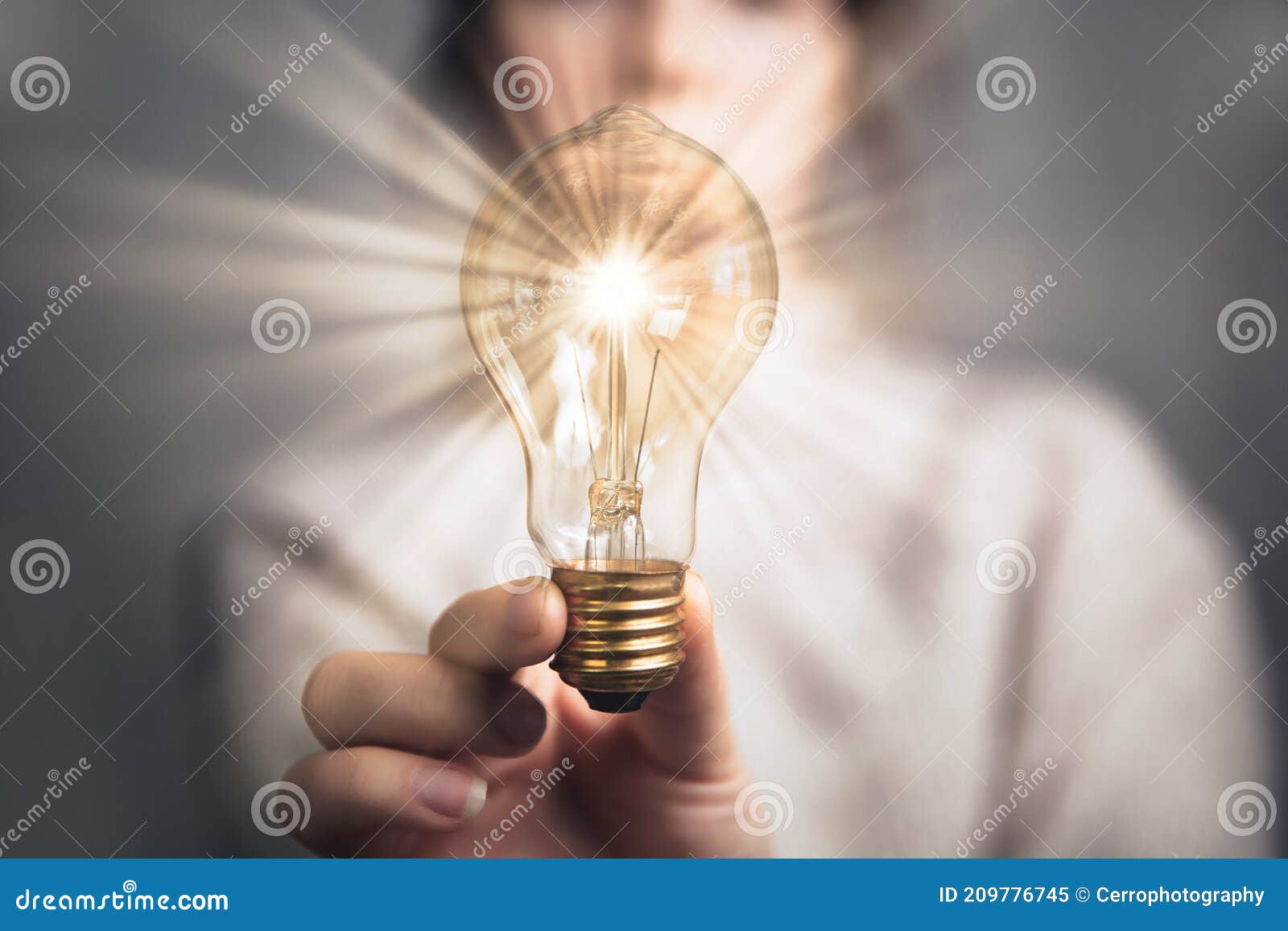 female hand holding a shining light bulb, great idea, innovation and inspiration, business concept background
