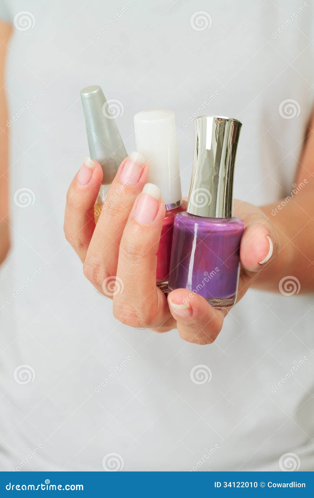 female hand with nail varnish bottles