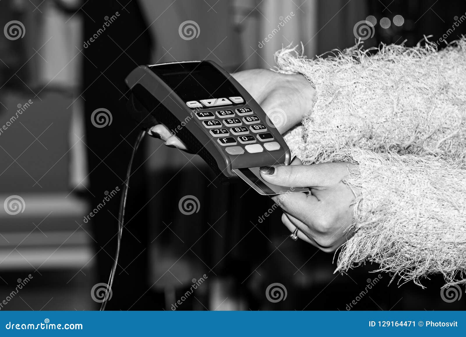 female hand puts bankcard into reader on defocused background