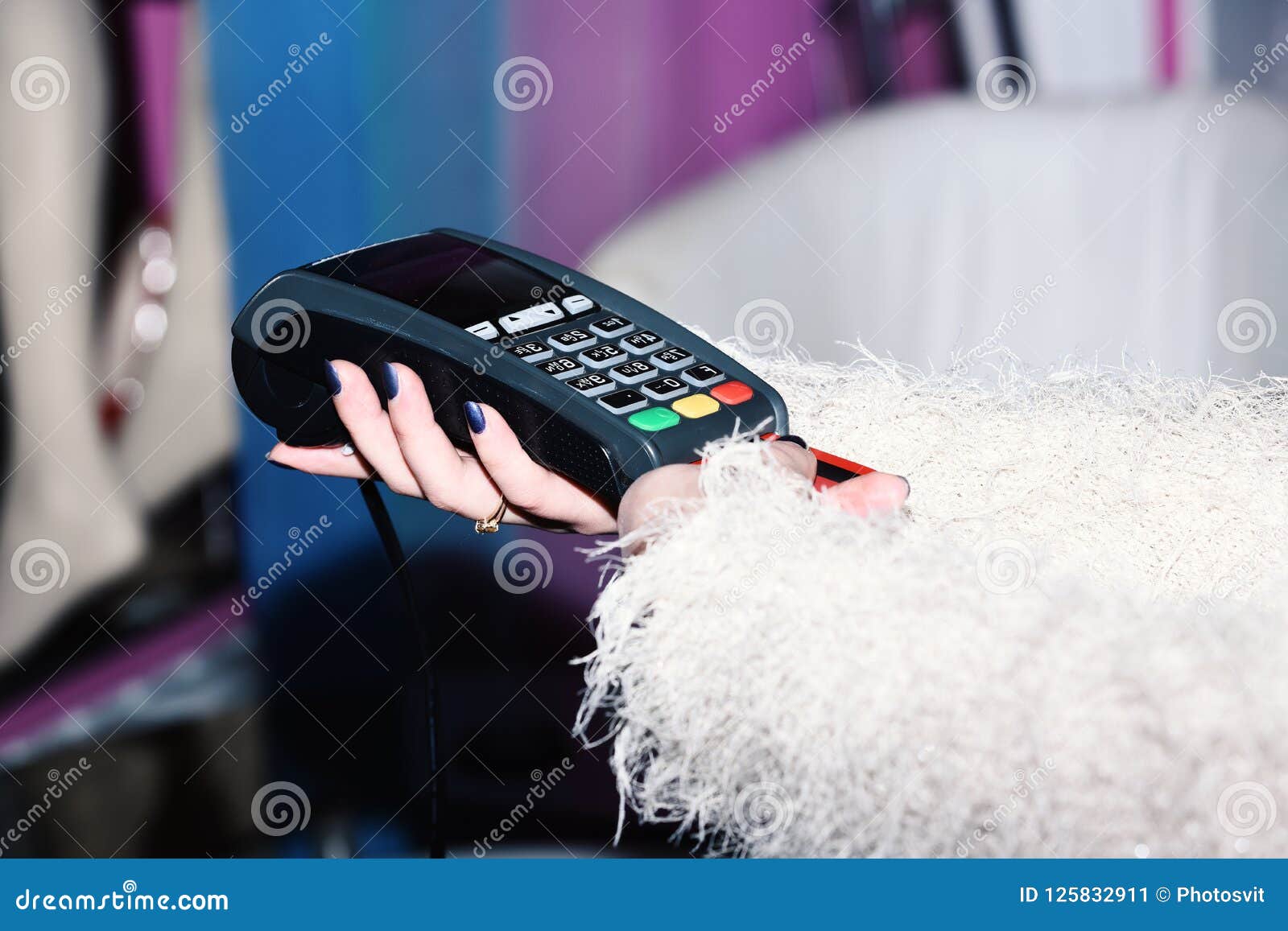 female hand puts bankcard into reader on defocused background. payment with credit card. edc machine or credit card