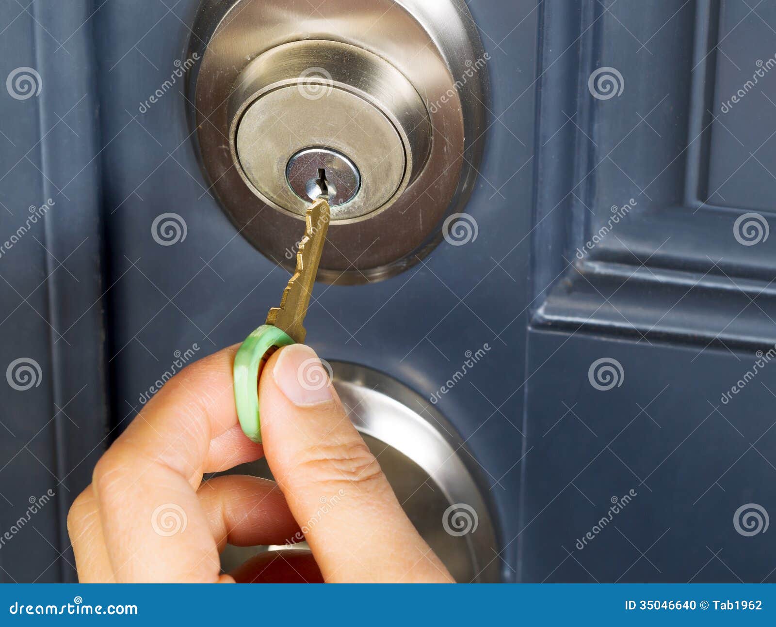 female hand putting house key into door lock