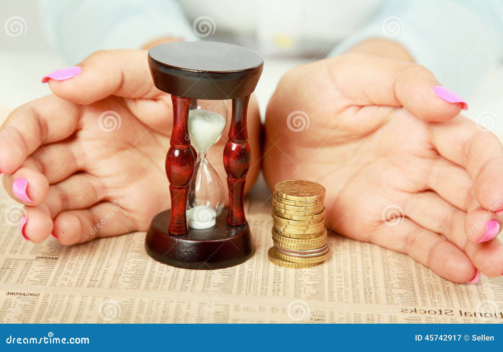 female hand's with hourglass and coin.