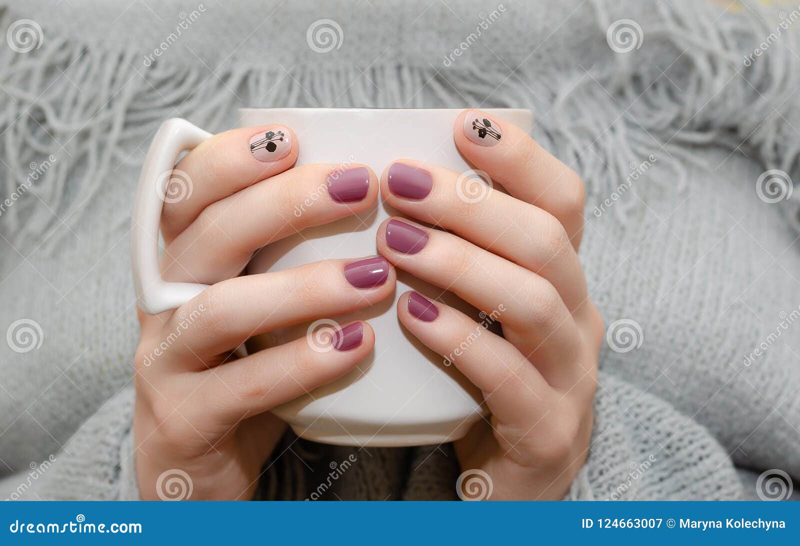 female hands dark pink nail design holding white cup 124663007