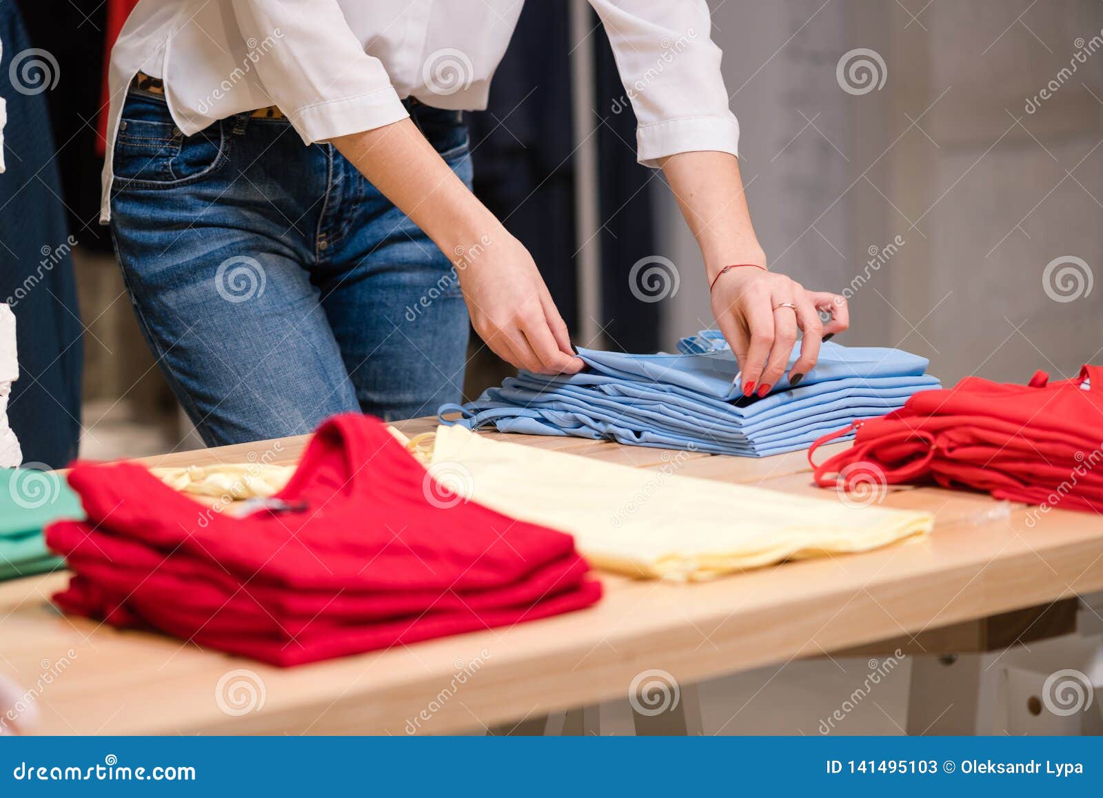 female fold blue clothes at clothing store