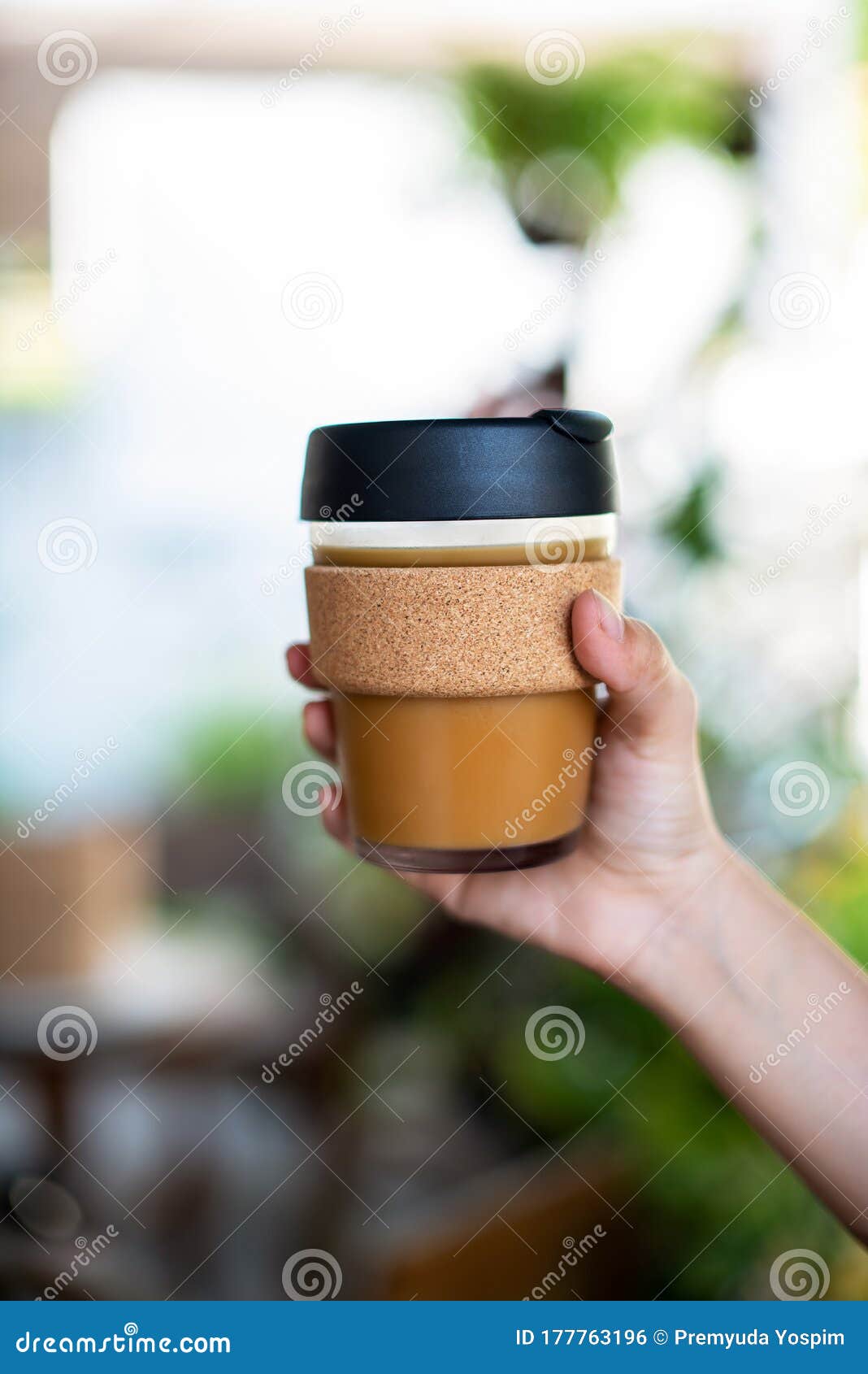 female hands holding reusable coffee cup,