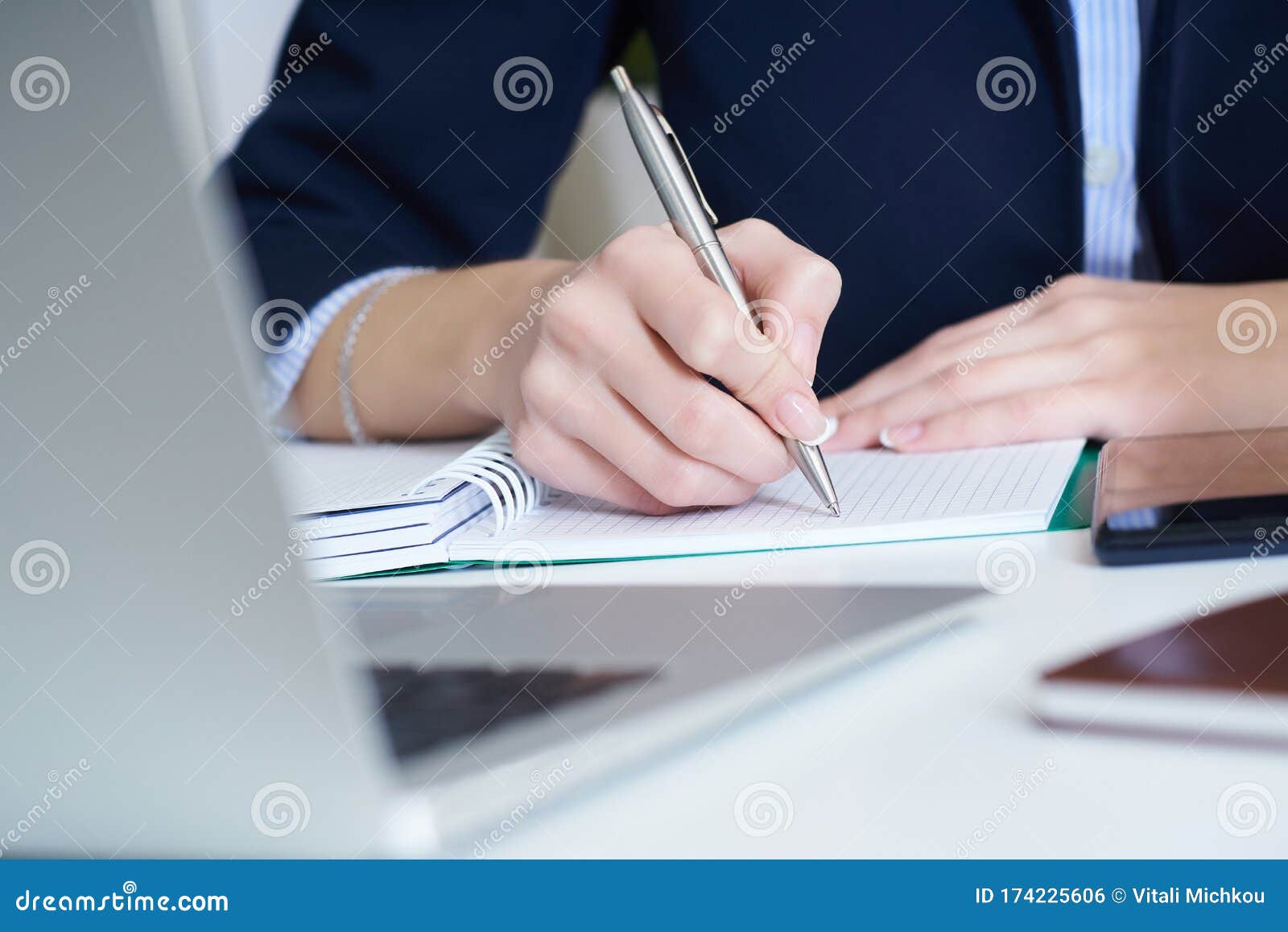 Young Businesswoman Writing in Notepad while Sitting at the Office ...