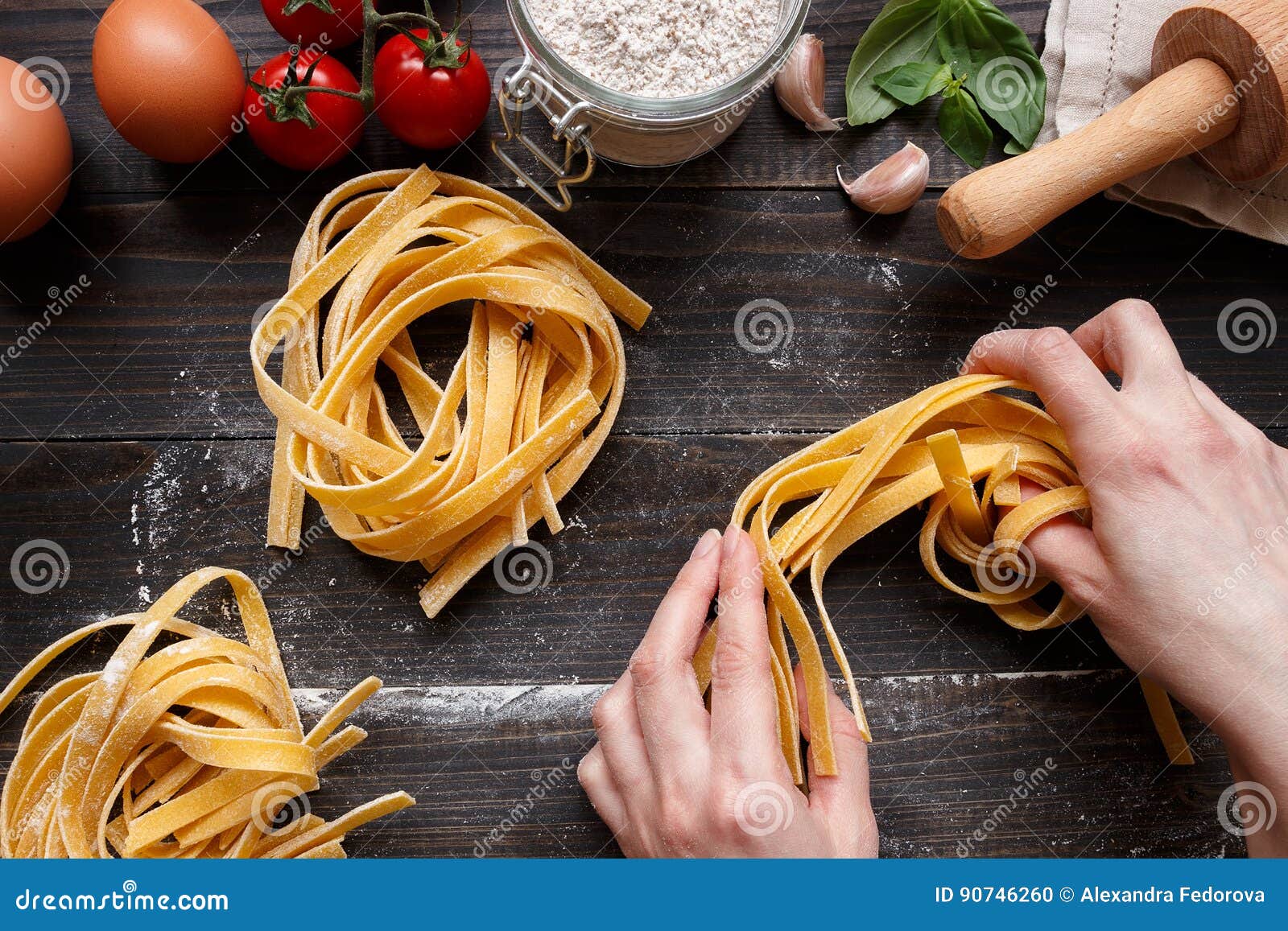 Female Hands Making Fresh Homemade Pasta. Pasta Ingredients on the Dark