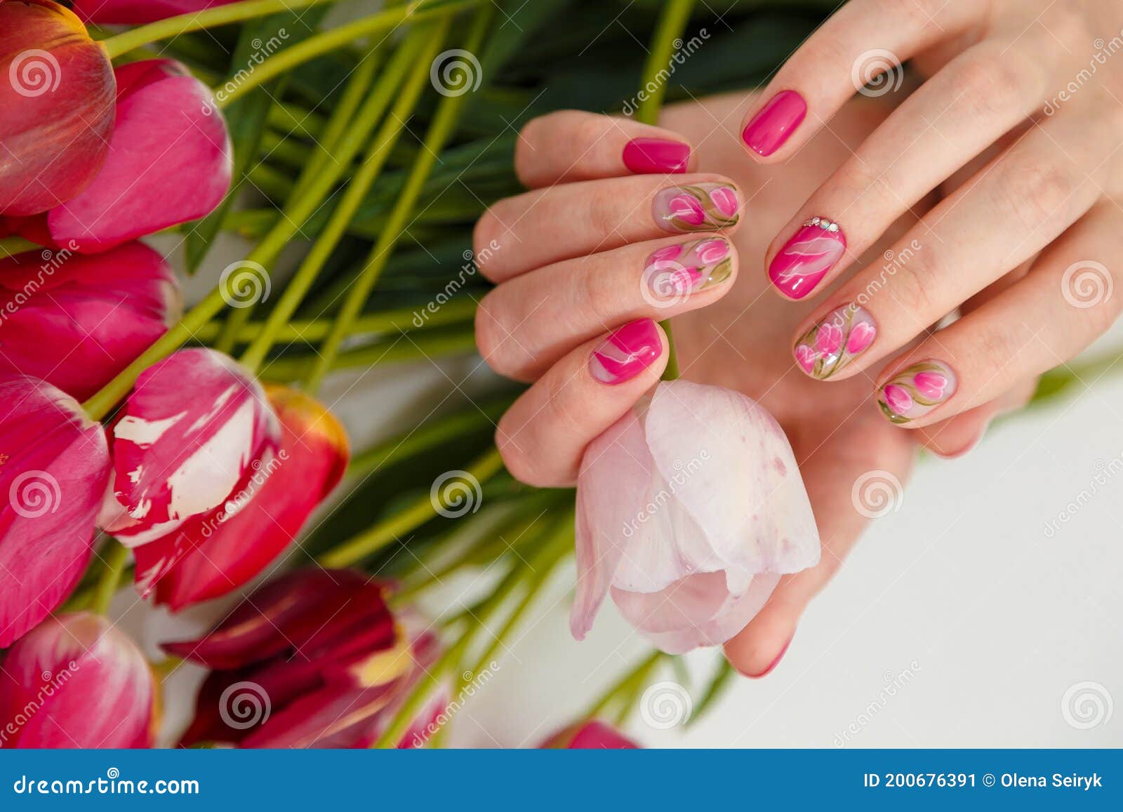 Yellow nail design. Female hand holding white tulip Stock Photo - Alamy