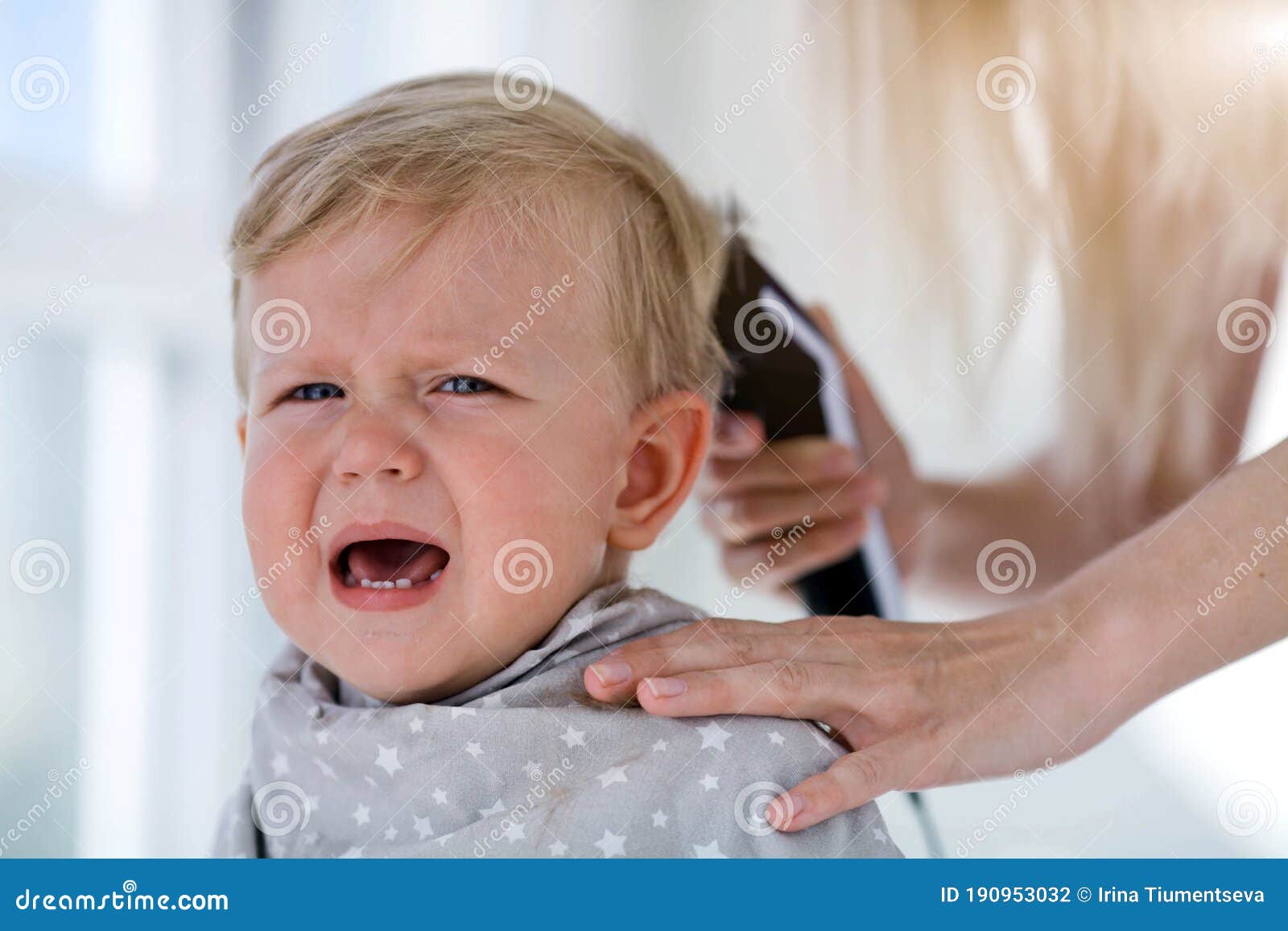 Female Hands Trim a Crying Baby with an Electric Hair Clipper in a  Hairdresser. First Haircut Stock Photo - Image of nipple, baby: 190953032