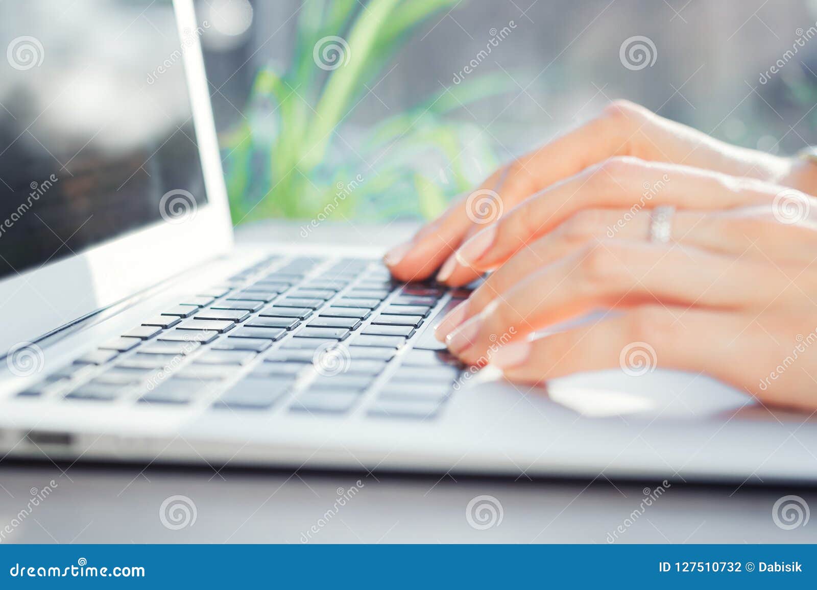 mixed race young woman typing on computer keyboard at table with