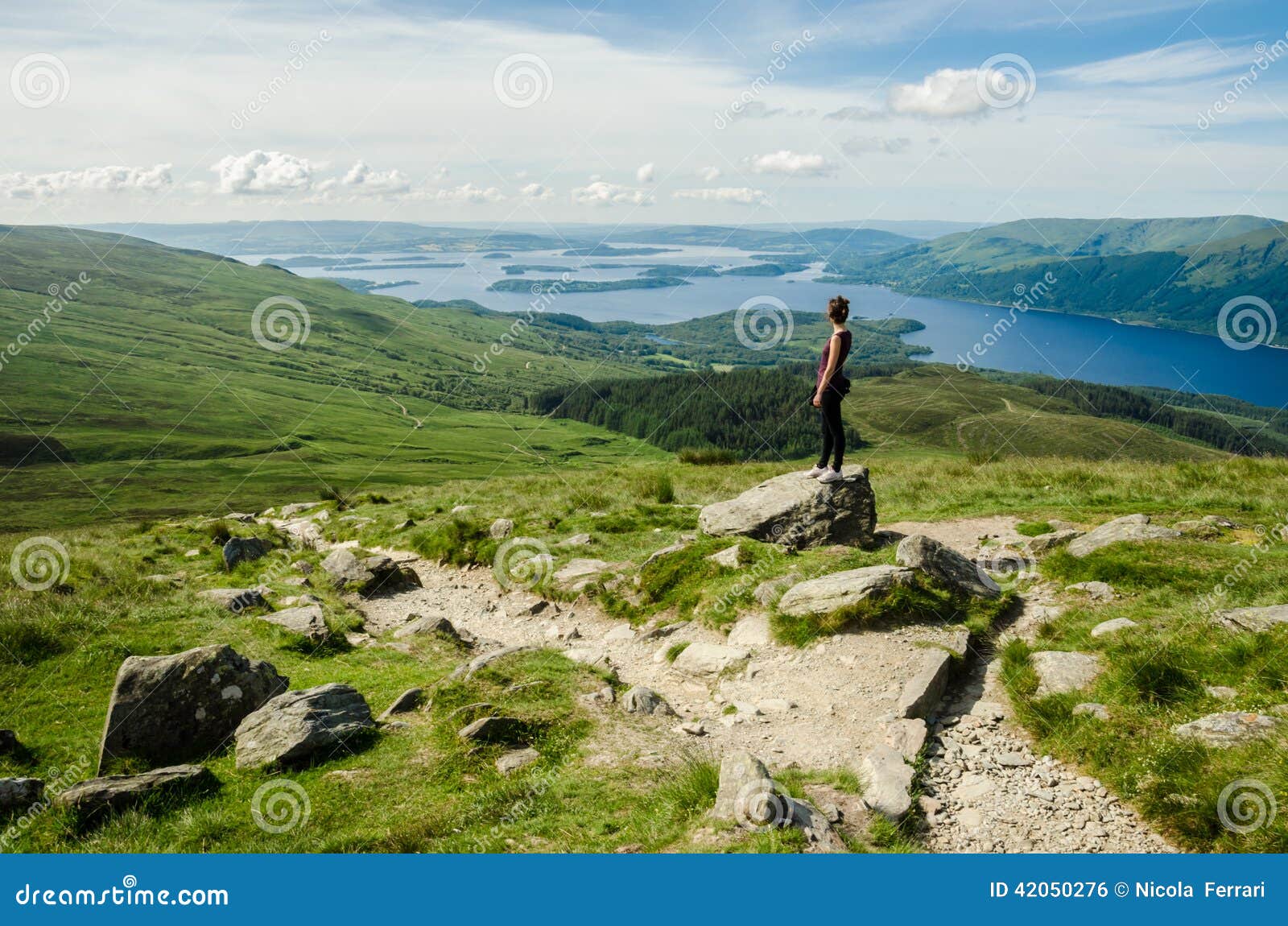 female hiker admiring the landscape on a path leading to the top