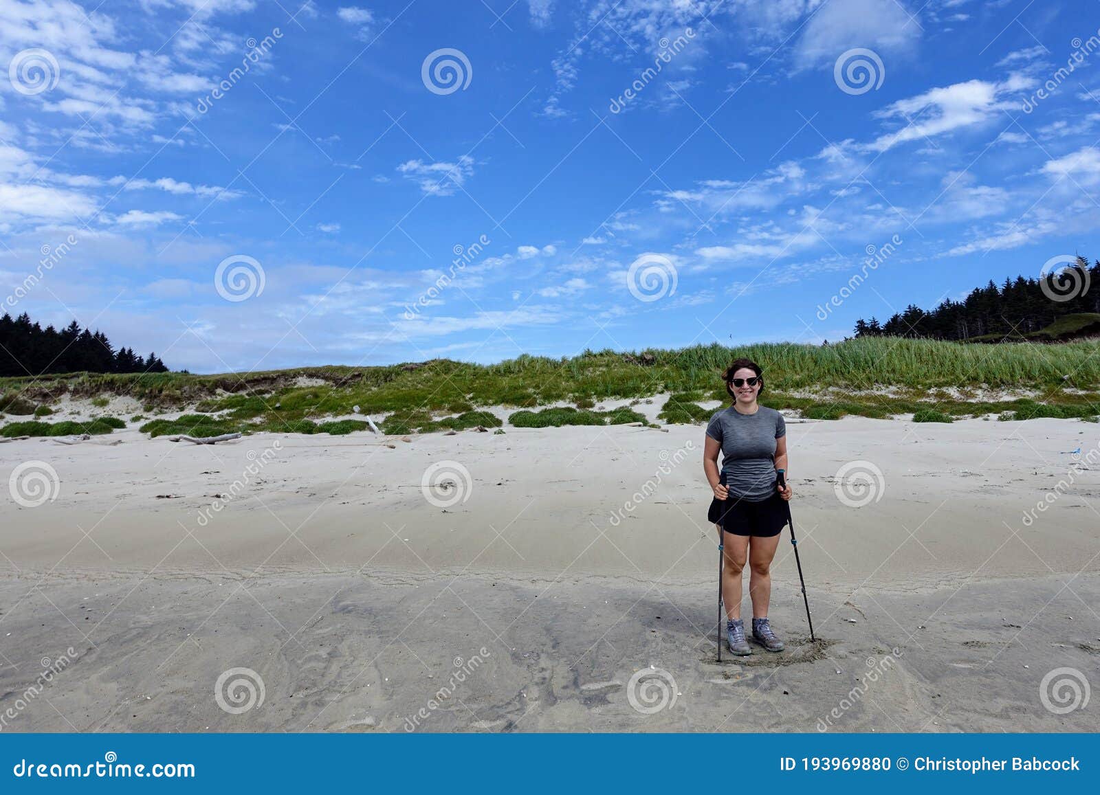 a female hiker exploring the sandy beaches of nels bight and experimental bight, surrounded by forest and the pacific ocean