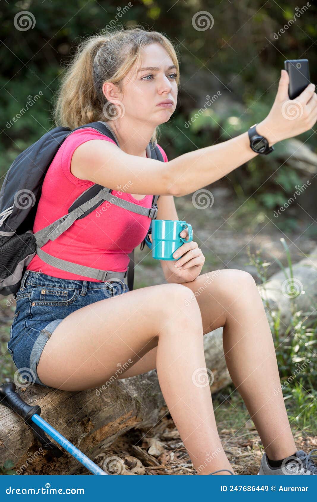 female hiker holding phone and searching signal