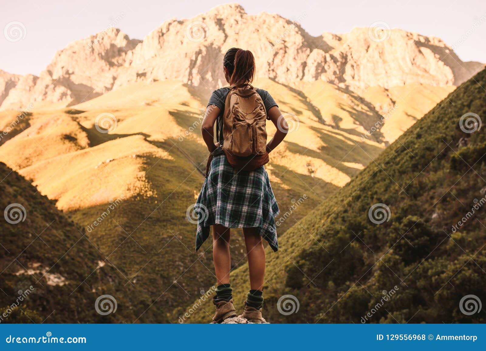 Woman hiking through mountain trail on a sunny day