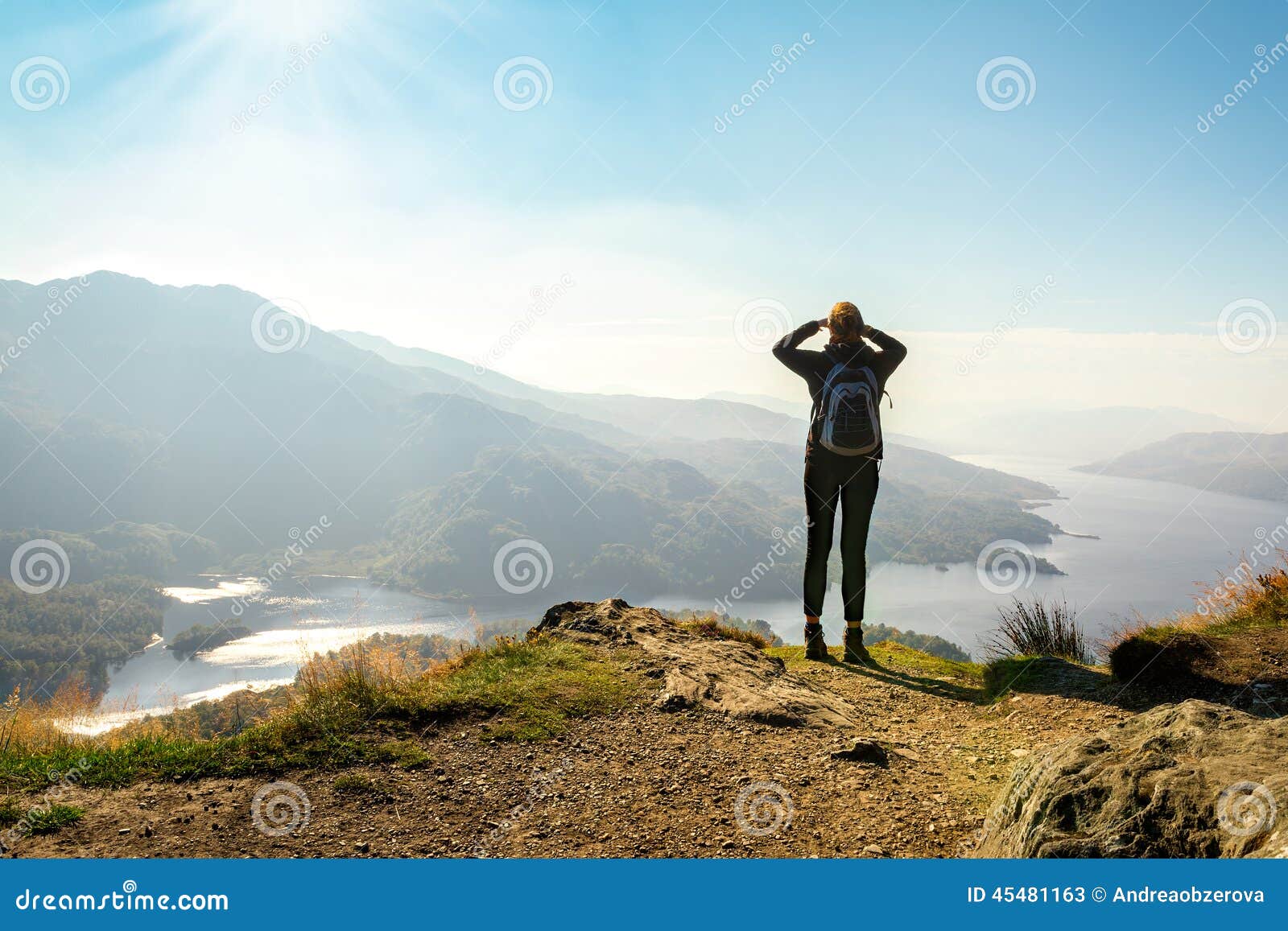 female hiker on top of the mountain enjoying valley view