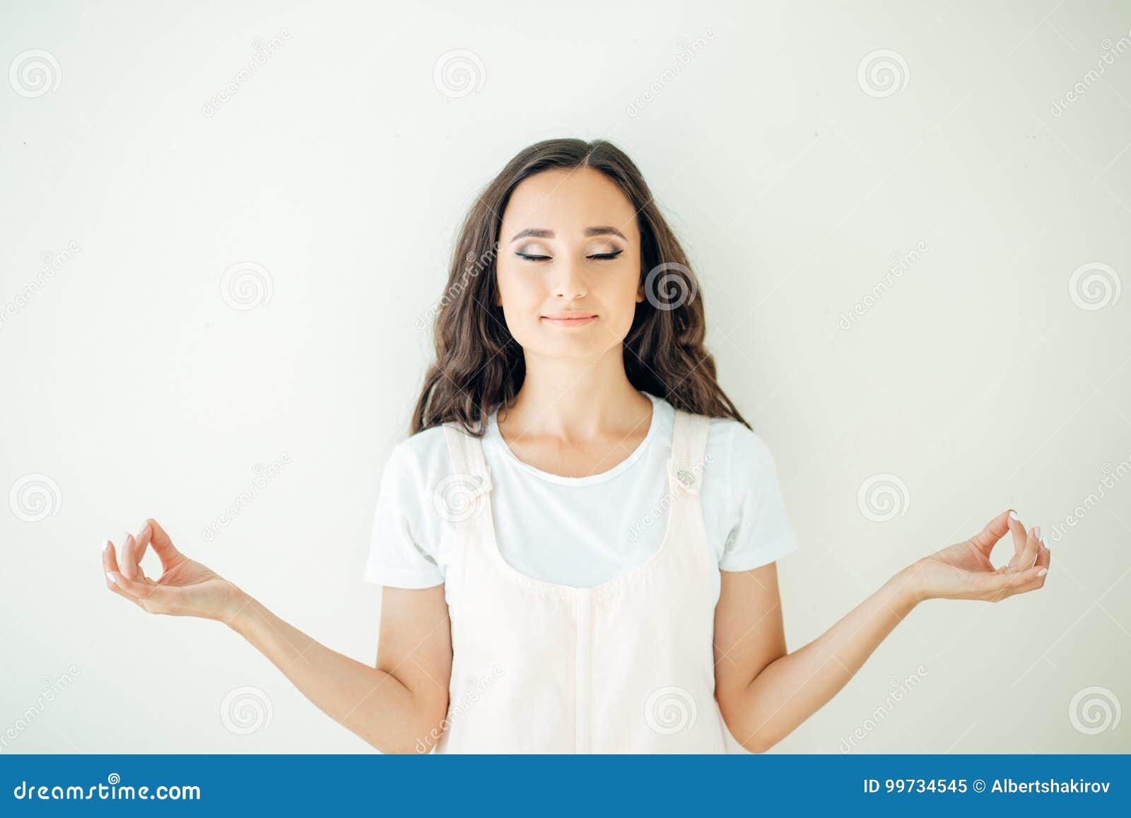 female holding hands in namaste or prayer, eyes closed while practising yoga