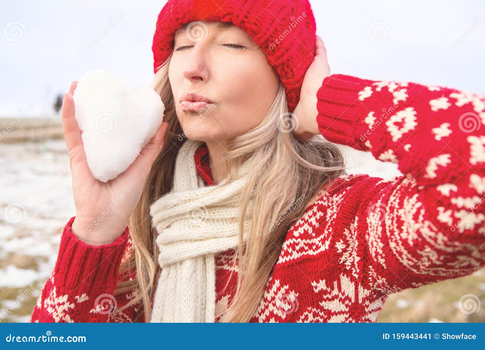 Female Holding Snowball in Shape of Heart Blowing Kisses Stock Image