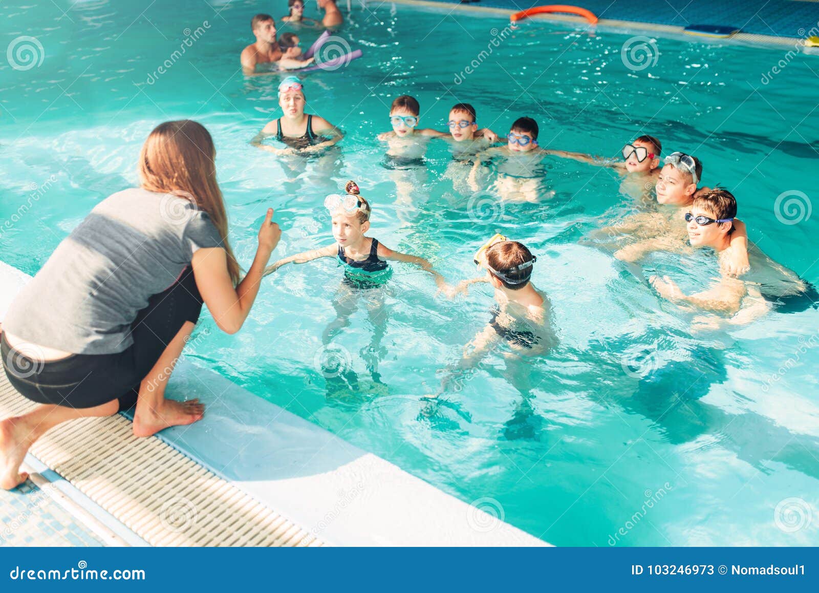 instructor teaches children how to swim