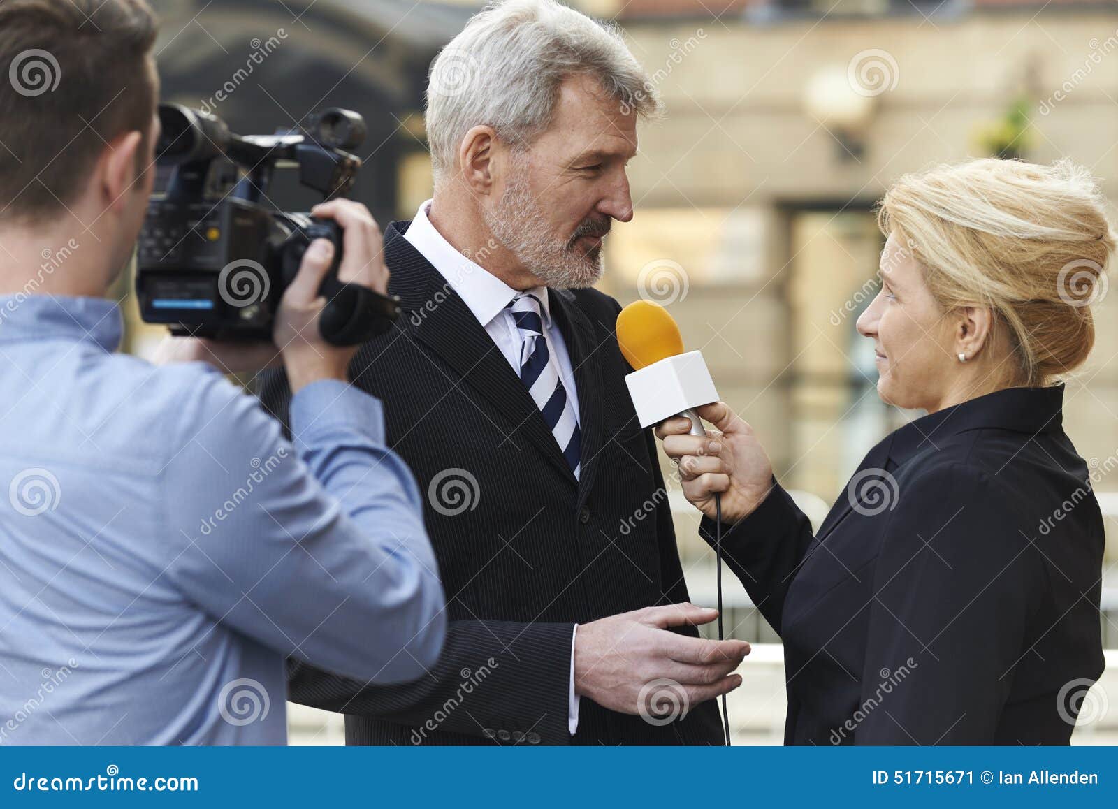 female journalist with microphone interviewing businessman