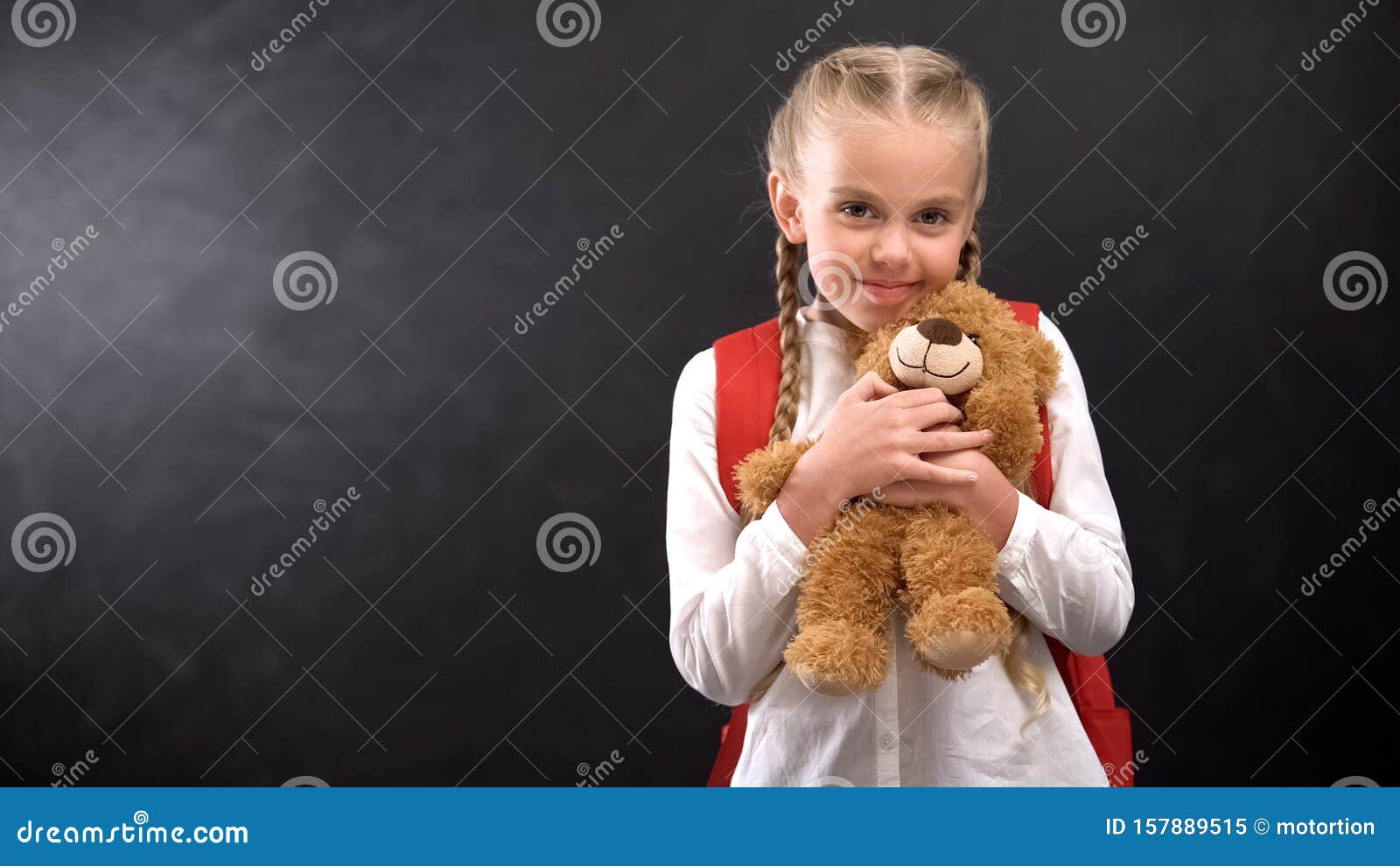 Female Kid with Rucksack Hugging Teddy Bear Smiling on Camera Against ...