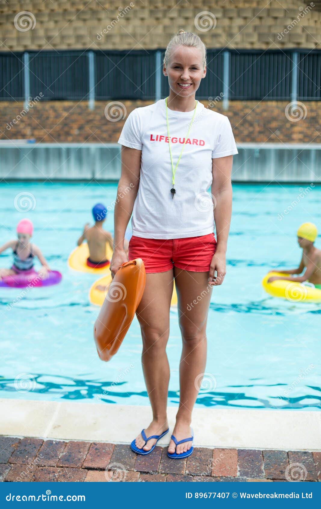 Female Lifeguard Holding Rescue Can at Poolside Stock Image