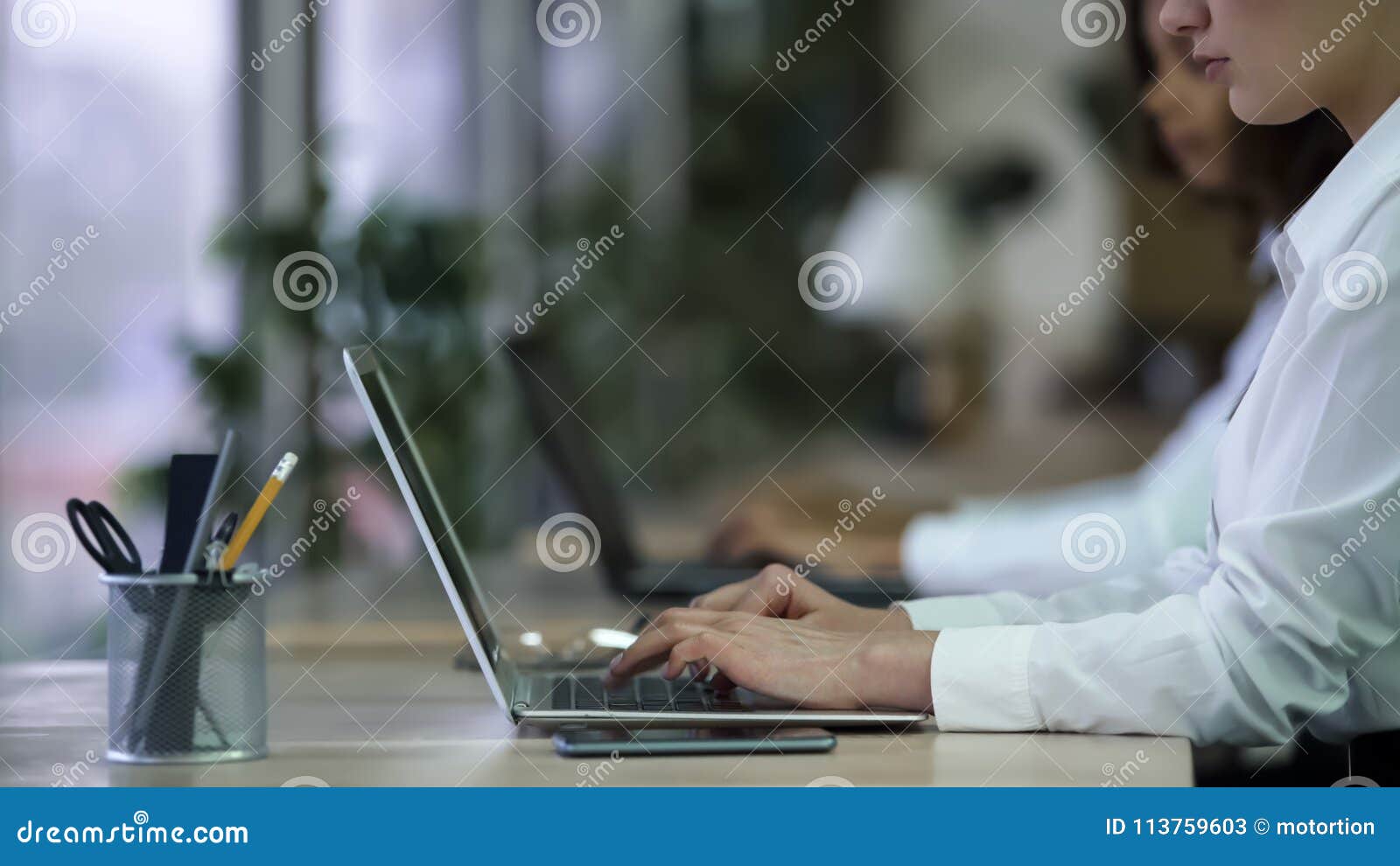 female manager working on laptop at company support center, contacting clients