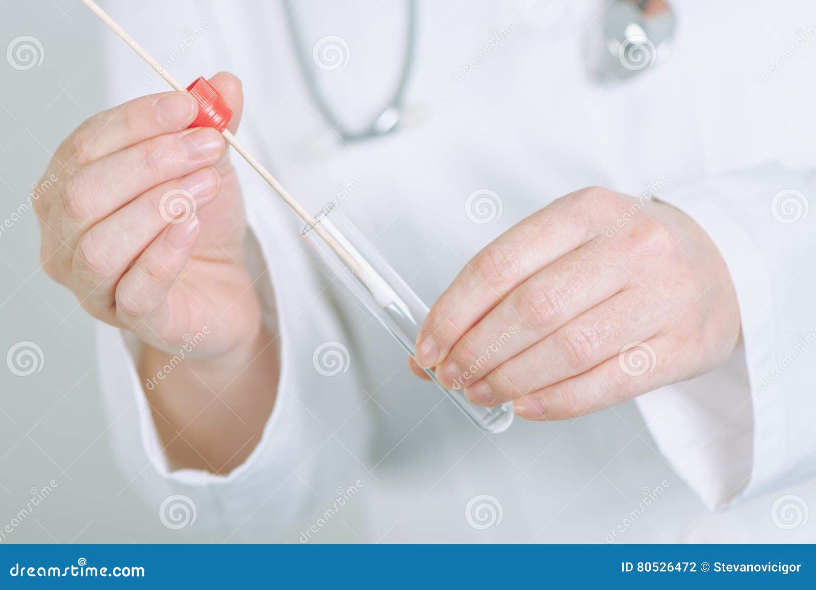 female medical specialist holding buccal cotton swab and test tu