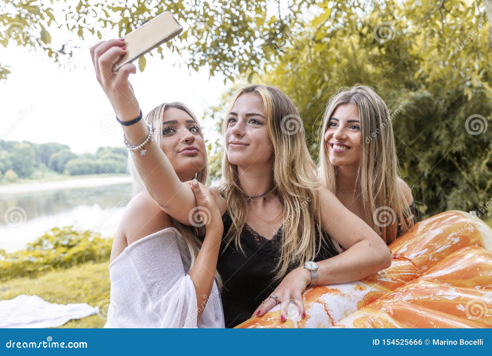 Female Millennial Girlfriends Taking A Selfie Outdoors On The River 