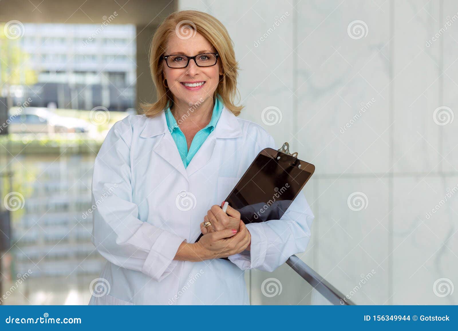 female nurse, doctor, health care practitioner, standing lifestyle working portrait in hospital hallway, smiling and cheerful