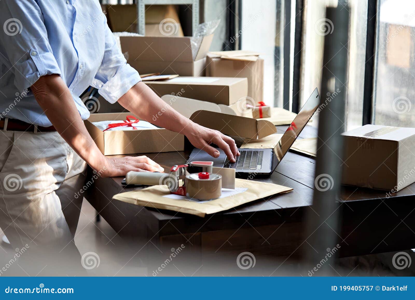 female online business owner packing shipping ecommerce parcel using laptop.