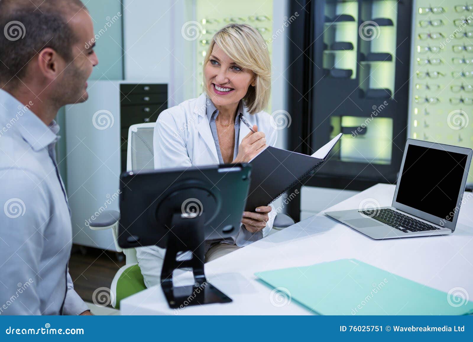 female optometrist talking to male patient