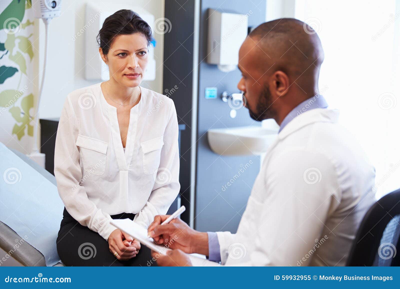 female patient and doctor have consultation in hospital room