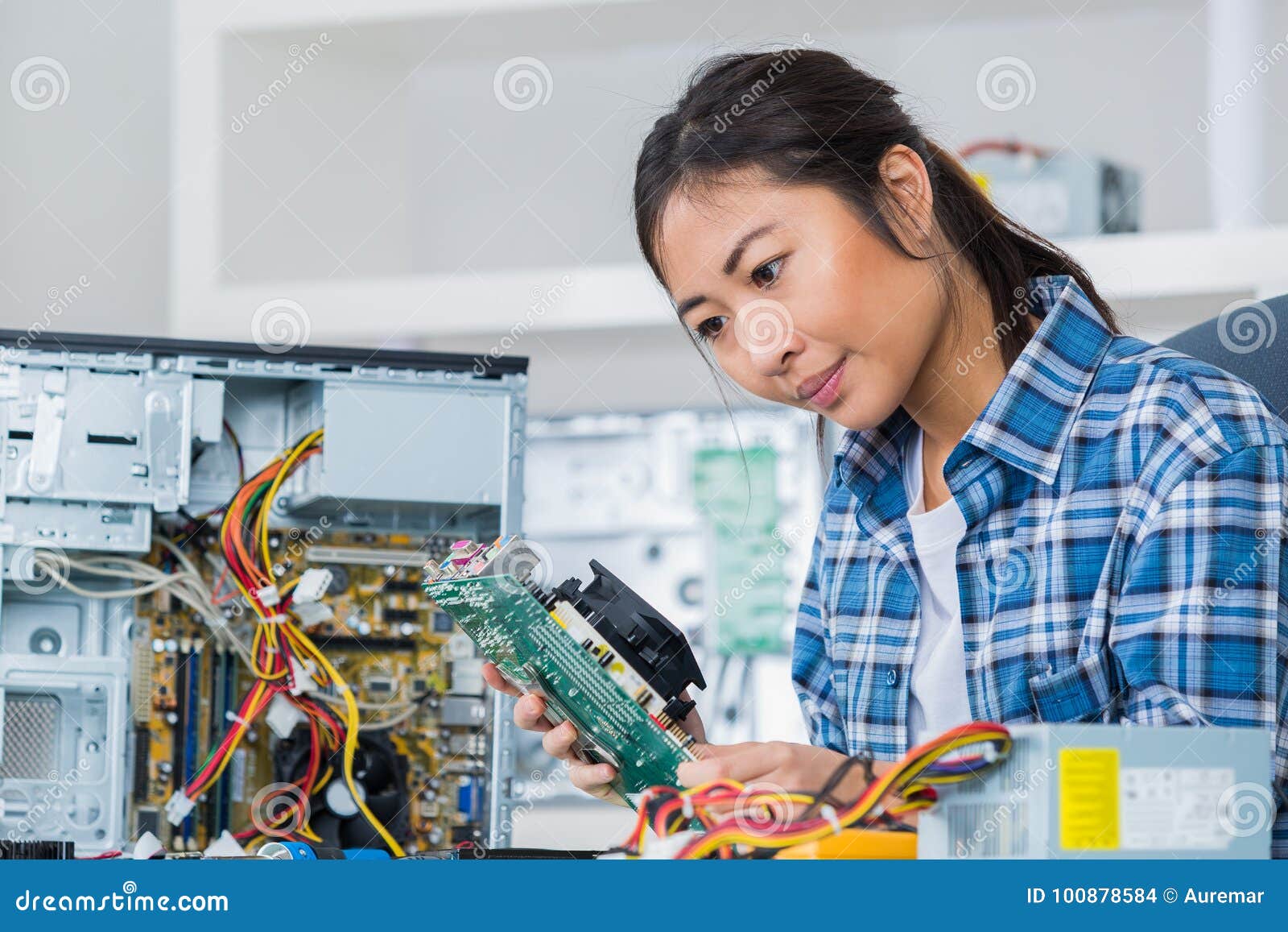 female pc technician posing next to disassembled desktop