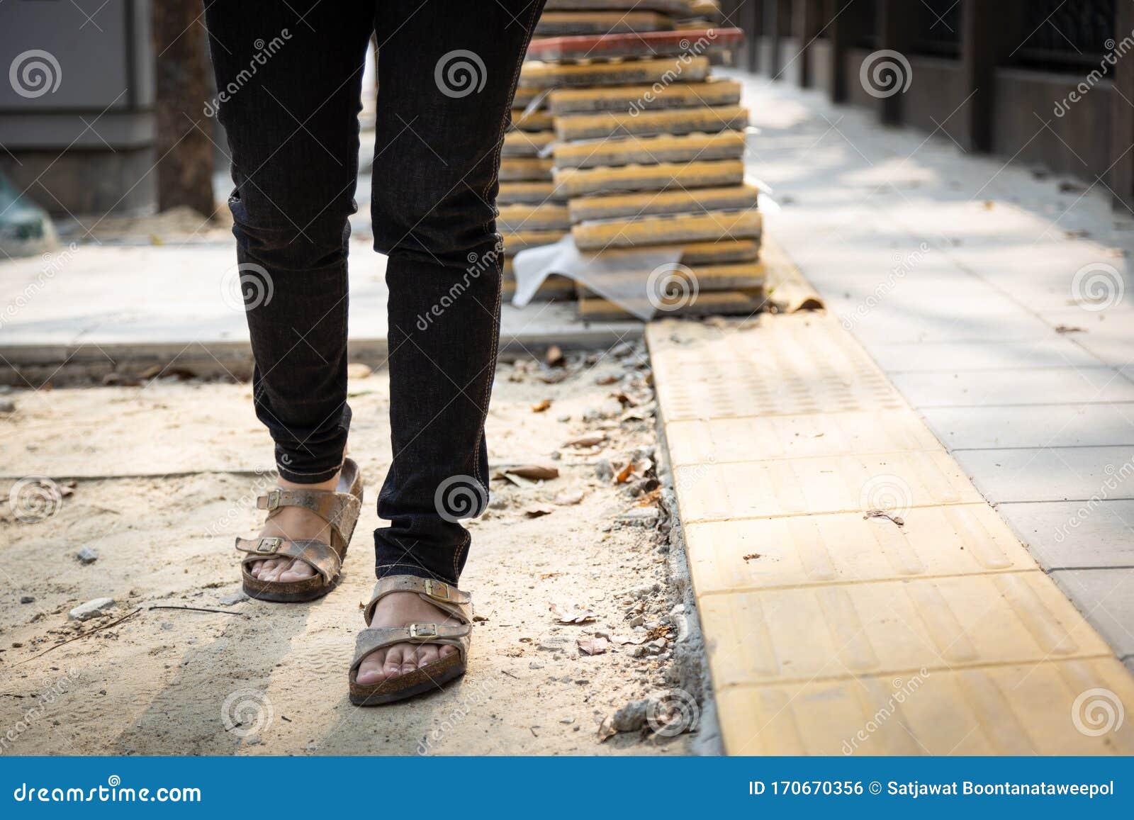 female pedestrians people is walking on a footpath walkway under construction and stacked cobblestone block or renovation,damaged