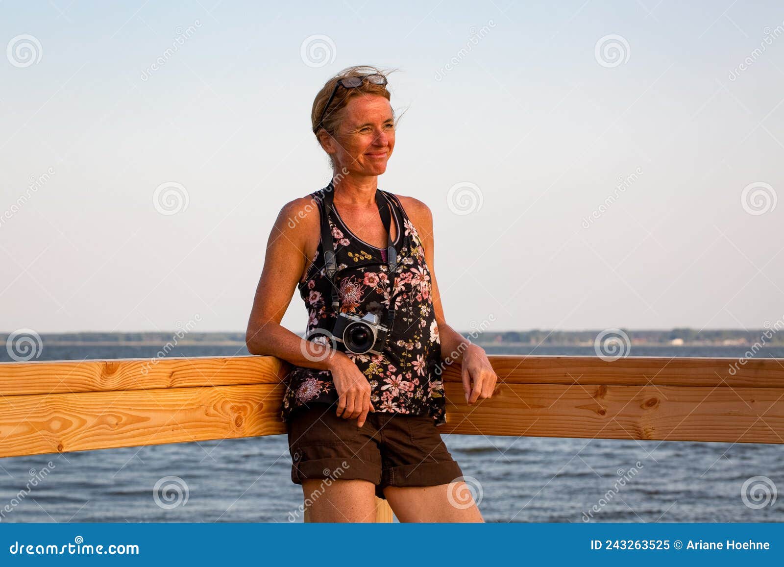 female photographer is standing at a lake