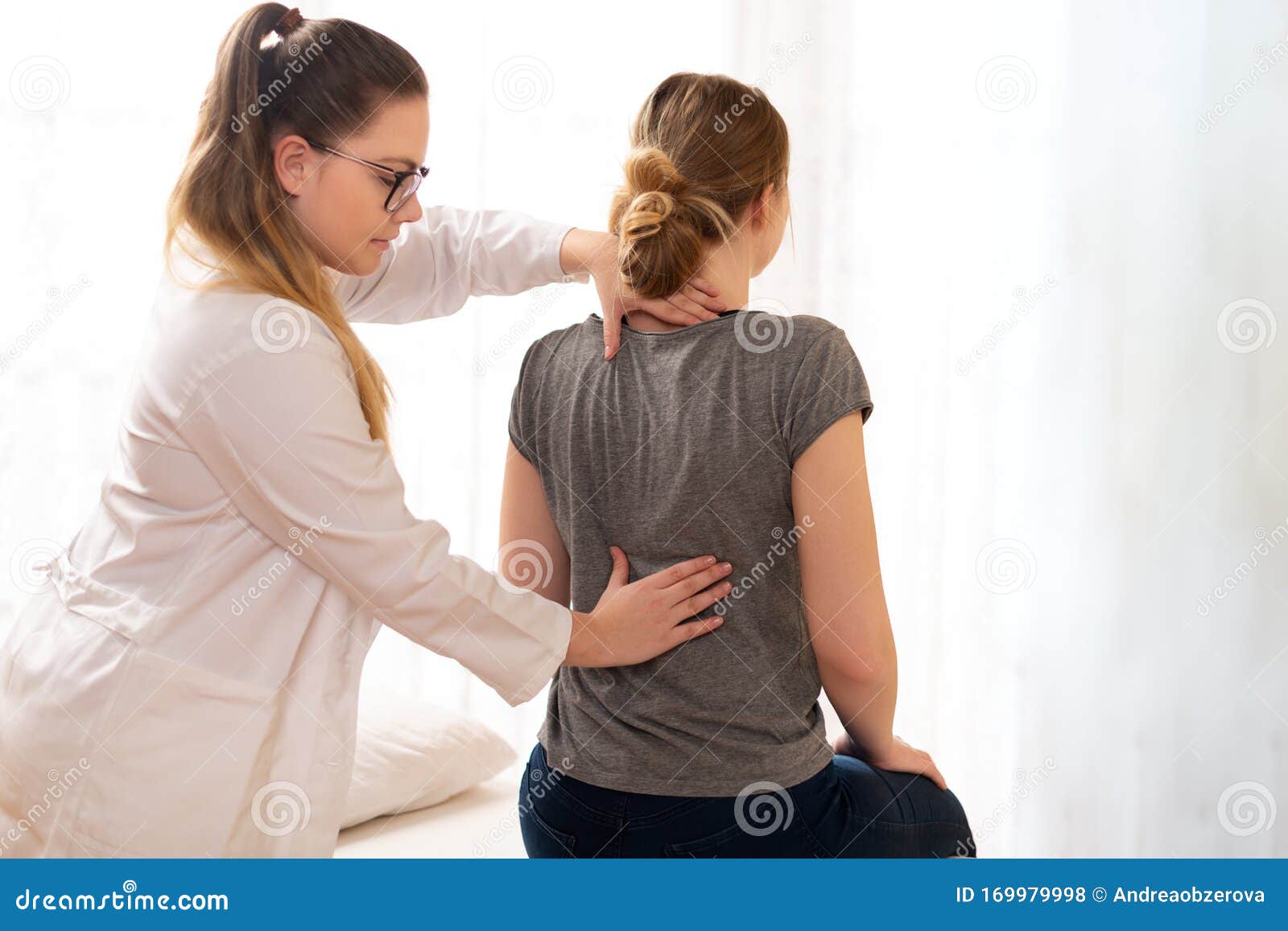 female physiotherapist or a chiropractor examining patients back. physiotherapy, rehabilitation concept.