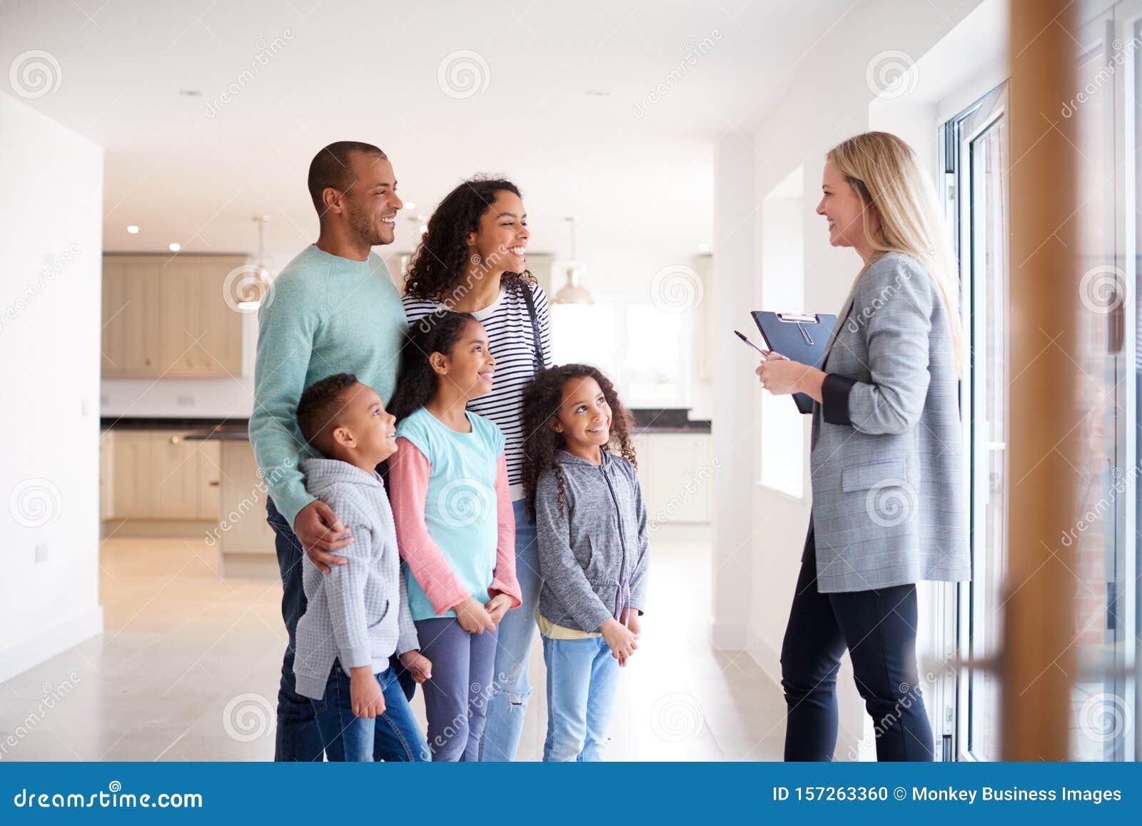 female realtor showing family interested in buying around house